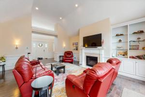 a living room with two red leather chairs and a fireplace at Cape Castle in Mashpee
