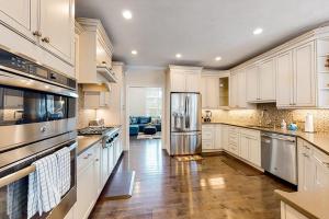 a kitchen with white cabinets and a stainless steel refrigerator at Cape Castle in Mashpee