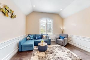a living room with a blue couch and two chairs at Cape Castle in Mashpee +36 photos