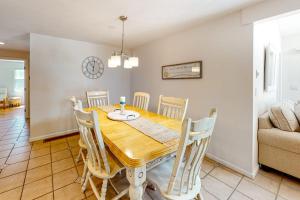 a dining room with a wooden table and chairs at Sea You Later in West Yarmouth