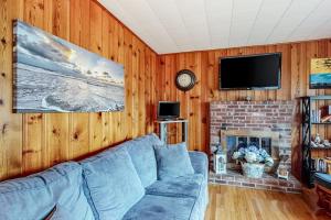 a living room with a blue couch and a fireplace at Anchors Await in South Yarmouth