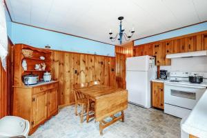 a kitchen with a table and a white refrigerator at Anchors Await in South Yarmouth