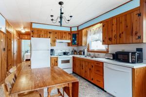 a kitchen with wooden cabinets and a wooden table at Anchors Await in South Yarmouth +17 photos