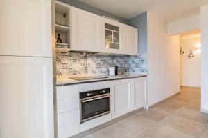 a kitchen with white cabinets and a stove at Tra il Borgo e il Mare - Bel Horizonte in Capoliveri