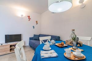 a living room with a blue table and a couch at Tra il Borgo e il Mare - Bel Horizonte in Capoliveri +26 photos