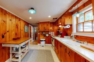 a kitchen with wooden walls and a sink and a window at Sweet Victory in Harwich Port