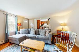 a living room with a couch and a table at Dream Dennis Getaway in Dennis