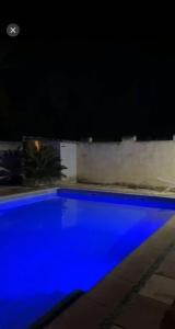 a blue swimming pool at night at Maison 4 pièce , piscine in Avignon