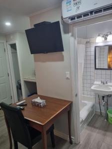 a kitchen with a table and a bathroom with a sink at Manor Motel in Southampton +44 photos