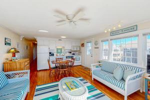 a living room with two couches and a kitchen at Bay Colony Vista in Provincetown