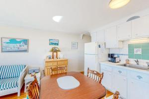 a kitchen with a table and a kitchen with a refrigerator at Bay Colony Vista in Provincetown +10 photos