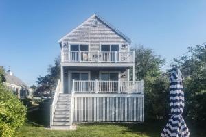 a large white house with a porch and a deck at Barnstable Harbor Home in Barnstable