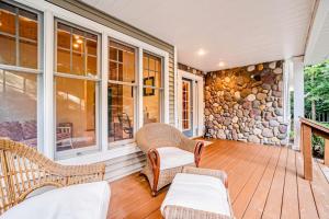 a porch with wicker chairs and a stone wall at Between the Lakes in Glen Arbor