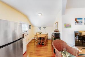 a kitchen with a refrigerator and a table with chairs at Everyday is Saturday in Vineyard Haven