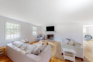 a white living room with a couch and a fireplace at New England Getaway in Dennis