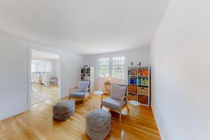 a living room with two chairs and a book shelf at New England Getaway in Dennis