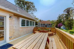 a large wooden deck with benches on a house at New England Getaway in Dennis +36 photos
