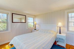 a bedroom with a bed and two lamps and a mirror at Adventures on Buzzards Bay in Bourne +18 photos