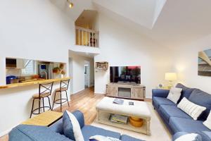 a living room with a blue couch and a kitchen at South Cape Escape in Mashpee