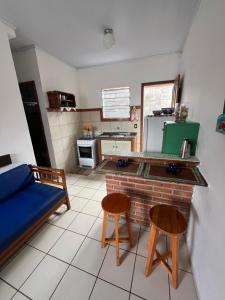 a kitchen with a couch and two chairs in a room at Casa quadra praia Jacaraipe! in Jacaraípe