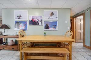 a dining room with a wooden table and pictures on the wall at Boyne Mountain Getaway, Unit B in Boyne Falls
