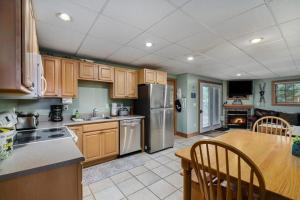 a kitchen with wooden cabinets and a table and a refrigerator at Boyne Mountain Getaway, Unit B in Boyne Falls +11 photos