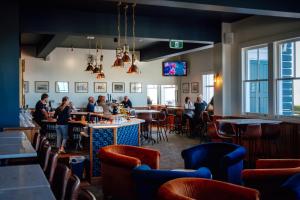 a bar with people sitting at tables in a restaurant at The Pier Hotel in Kaikoura