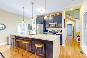 a kitchen with blue cabinets and bar stools at The Lighthouse in Lakeshore Cottages in Union Pier
