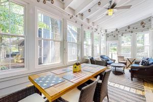 a dining room with a table and chairs and windows at The Lighthouse in Lakeshore Cottages in Union Pier