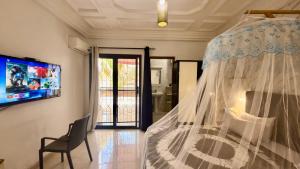 a bedroom with a bed with a mosquito net at Jade guest House in Dakar