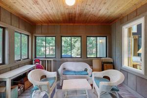 a room with chairs and a table and windows at The Treehouse in Thompsonville