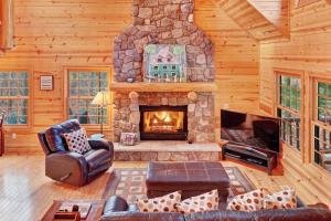 a living room with a stone fireplace in a cabin at Kingfisher Cove Cabin 28 in Saugatuck