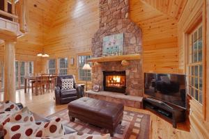 a living room with a stone fireplace in a log cabin at Kingfisher Cove Cabin 28 in Saugatuck