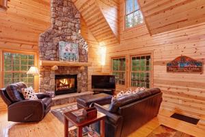 a living room with a stone fireplace in a log cabin at Kingfisher Cove Cabin 28 in Saugatuck