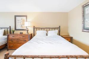 a bedroom with a large white bed and a wooden dresser at Mountain Top 713 in Thompsonville +26 photos
