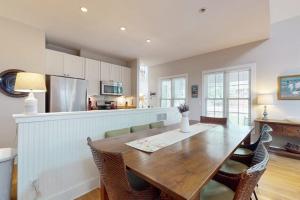 a kitchen with a wooden table and chairs and a kitchen with a counter at Seaglass Lakeshore Cottage in Union Pier
