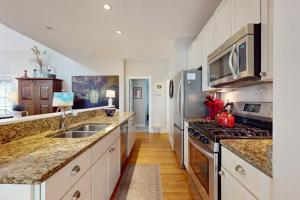 a kitchen with a sink and a stove at Seaglass Lakeshore Cottage in Union Pier +23 photos
