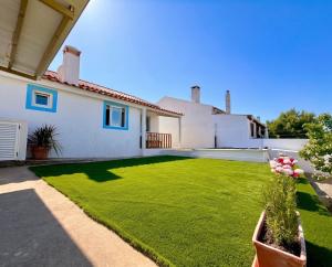 a large yard with a white house at Casinha do Cercal in Cercal