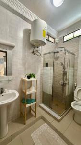 a bathroom with a shower and a sink and a toilet at Jade guest House in Dakar