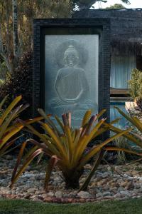 a picture of a statue in a garden at Villa Cozy - Pousada Boutique in Arraial d'Ajuda