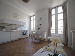 a kitchen and dining room with white cabinets and a table at NOUVEAUTE JUILLET 2026 Le BALCON DE L OPERA in Vichy