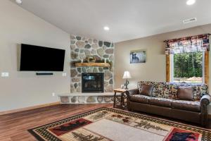 a living room with a couch and a stone fireplace at The Bear in Conover