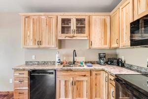 a kitchen with wooden cabinets and a black dishwasher at The Bear in Conover