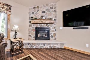 a living room with a stone fireplace with a flat screen tv at The Wildwood in Conover