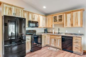 a kitchen with wooden cabinets and black appliances at The Woodland in Conover