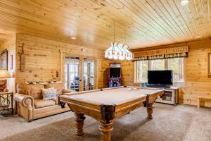 a game room with a pool table and a tv at Serenity at Stormy Lake in Conover
