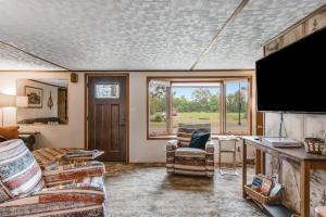 a living room with chairs and a flat screen tv at The Trail Hub in Mercer