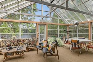 a glass conservatory with a couch and tables and chairs at Northwoods Oasis in Land O' Lakes