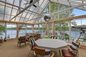 a large glass room with a table and chairs at Northwoods Oasis in Land O' Lakes