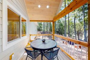 a screened in porch with a table and chairs at Chalet on the Bay in Saint Germain